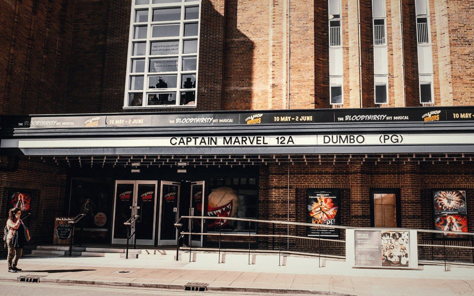 Cinema marquee displaying showtimes for Captain Marvel and Dumbo above the entrance doors