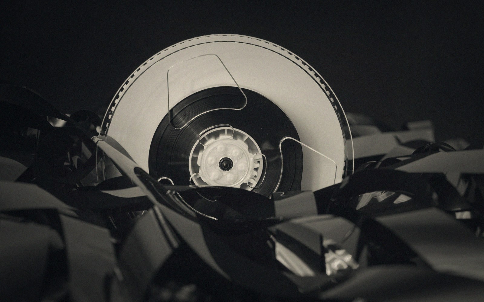 A film reel surrounded by tangled strips of unspooled celluloid